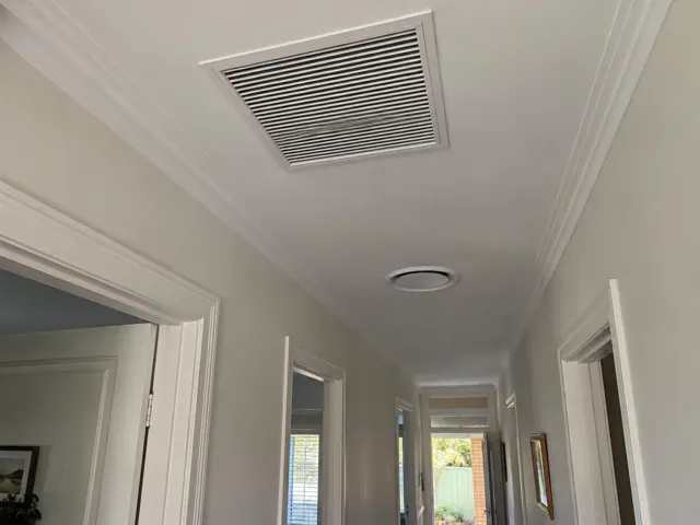 Ceiling return-air grille in a narrow hallway with white trim and light grey walls in Mitcham